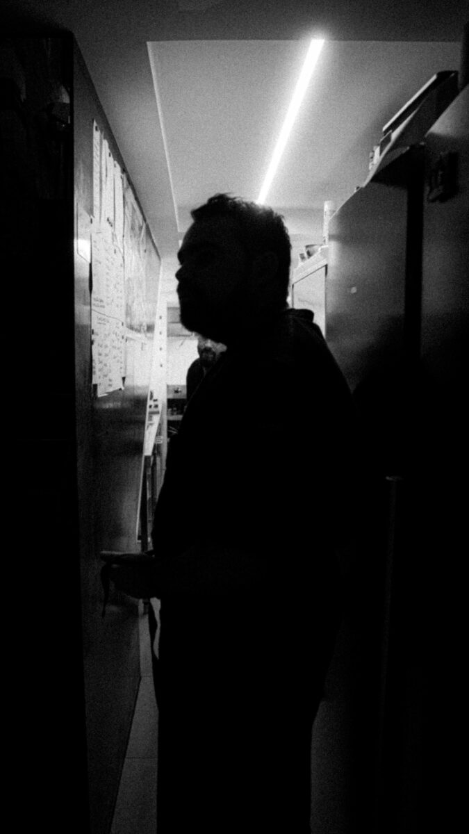 El chef Eduardo Llop con su cocina de fondo, en Les Amis, blanco y negro.