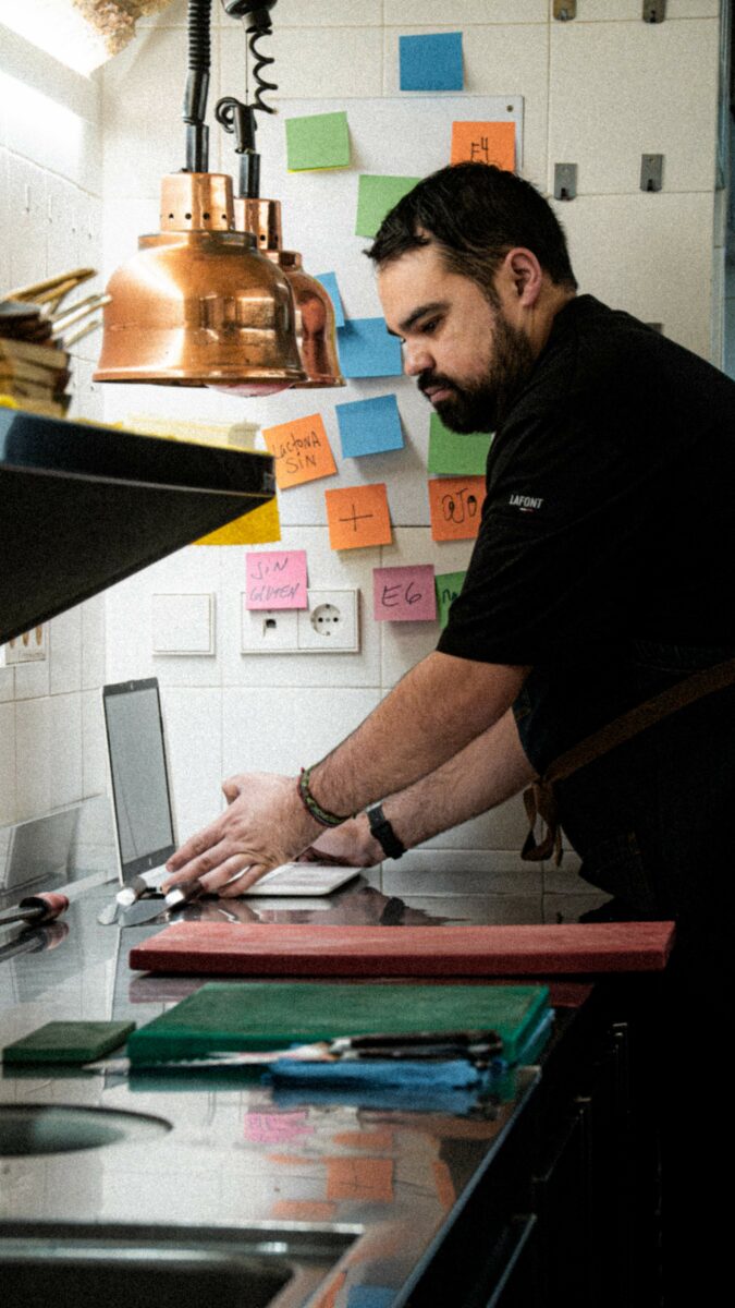 El chef Eduardo Llop manejando su ordenador en la cocina de Les Amis.