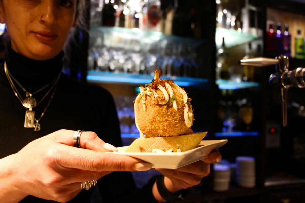 Vesla, camarera del Bar San Gregorio, nos muestra un pincho de bola de patatas panaderas con jamón y alioli.
